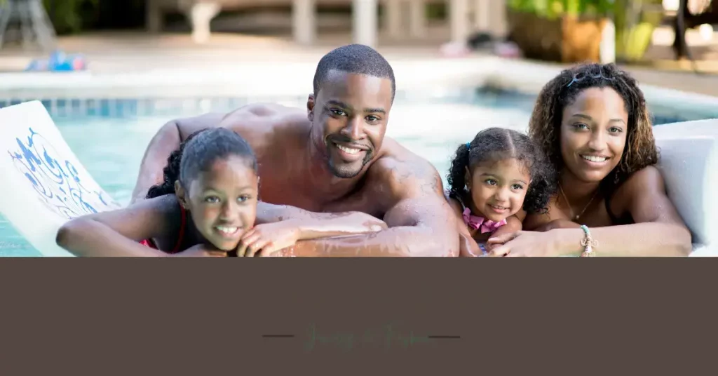 beautiful black - african american family father mother 2 daughters in a swimmingpool smiling mother with jewelry bracelet